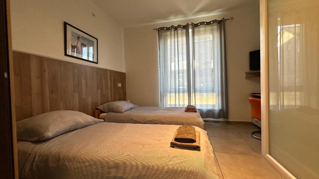 a bedroom with two beds and a window at Zimmervermietung Aras in Paderborn