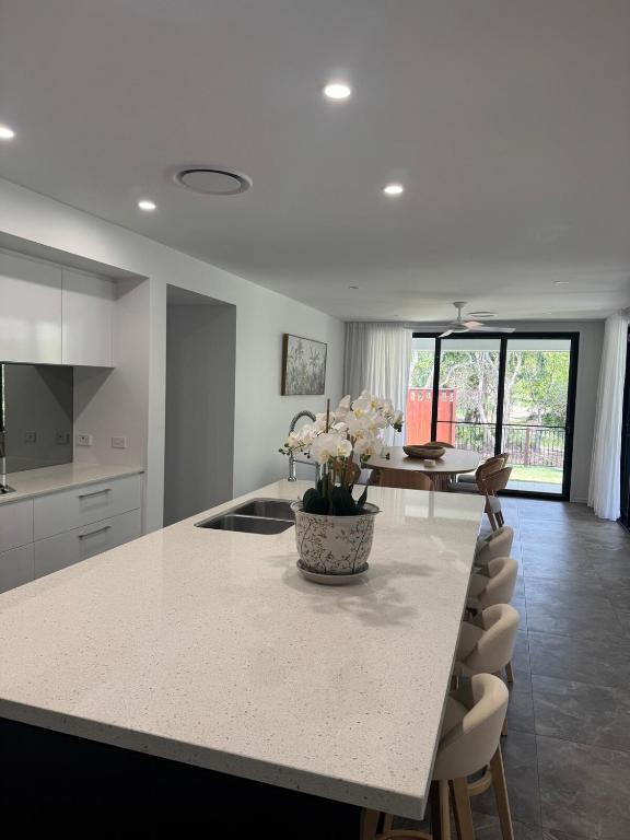 a kitchen with a table and a vase with flowers on it at The Ponds at Mudgeeraba in Gold Coast