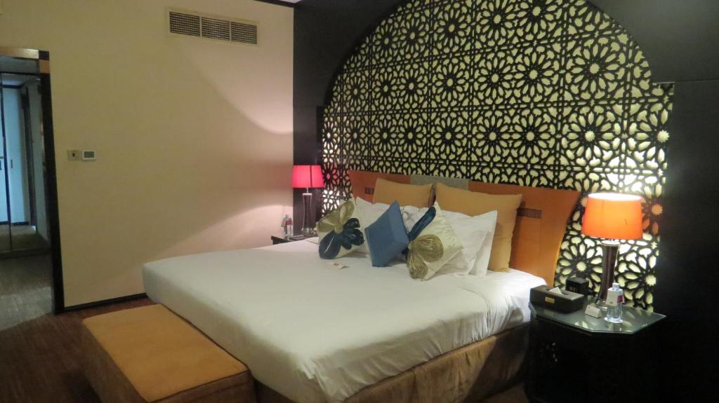 a bedroom with a bed with a black and white headboard at THE PARK HOTEL Formerly Al Jawhara Gardens in Dubai