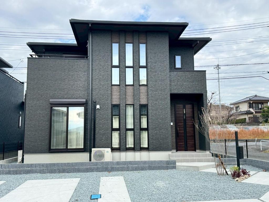a black brick house with a large window at Akikawa Koshi 12 プレミアム木造 一棟貸切ヴィラ in Yuge