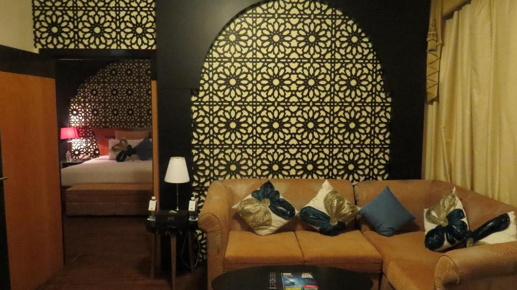 a living room with a couch and a bed at THE PARK HOTEL Formerly Al Jawhara Gardens in Dubai