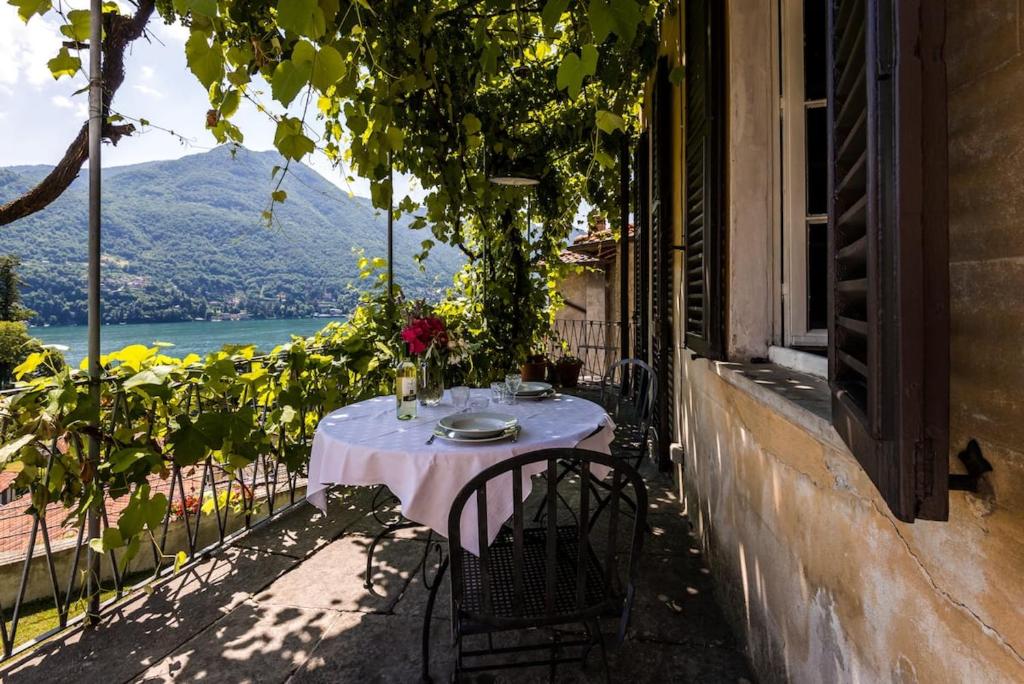 a table on a balcony with a view of a lake at Terrace with a view! in Moltrasio