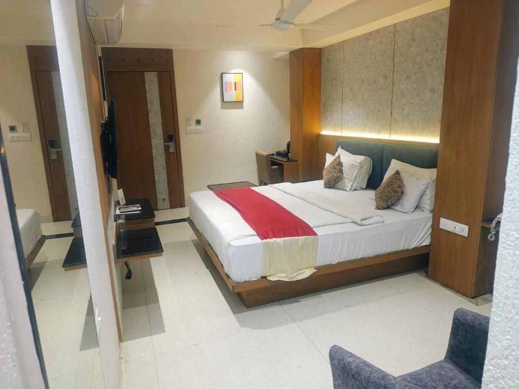 a hotel room with a bed and a chair at Hotel Ranjeet Akola in Akola