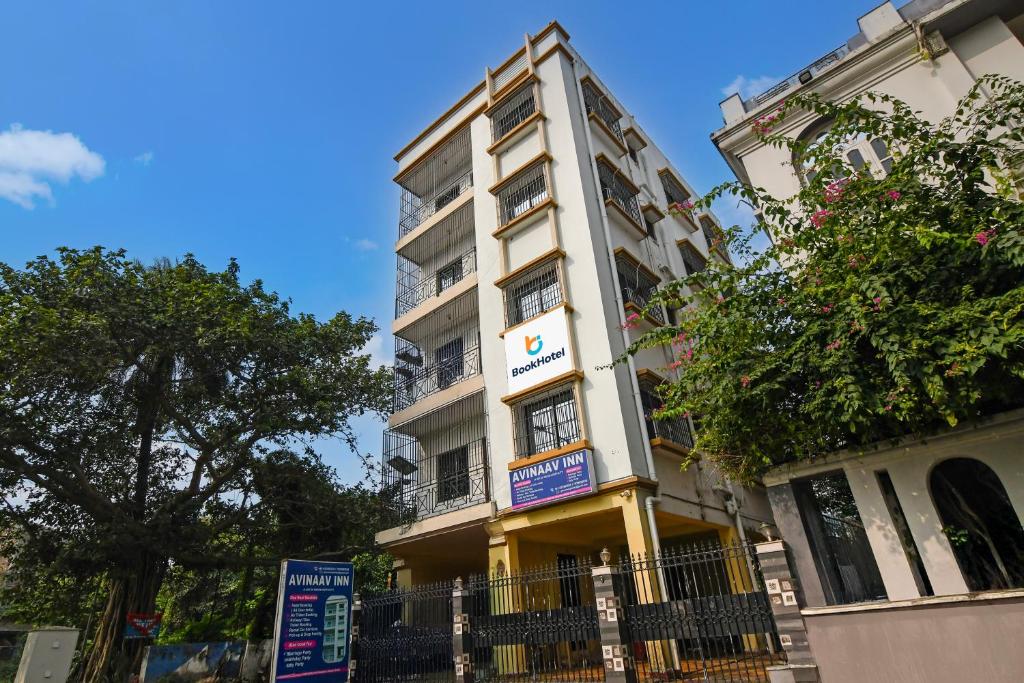 a tall white building with a sign on it at Avinaav Inn in New Town