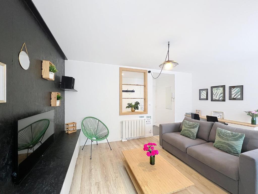 a living room with a couch and a table at Le Forum - Appartement rare - Parking privé - Centre - Reims in Reims