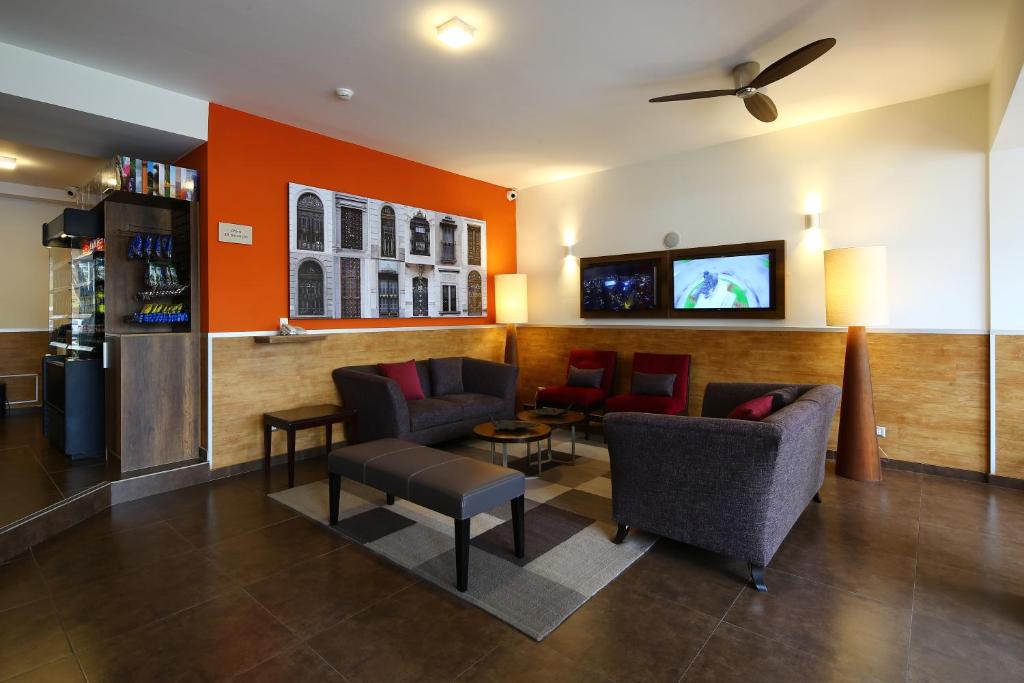 a waiting room with chairs and a tv on a wall at Casa Andina Standard Miraflores San Antonio in Lima