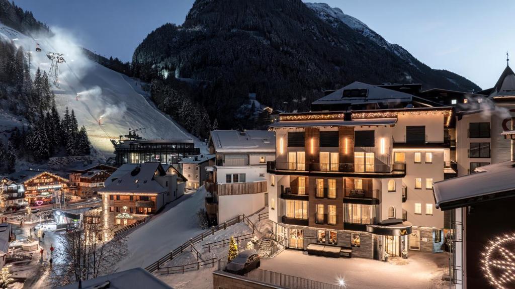 a hotel in a town with a mountain in the background at Hotel Vista Allegra in Ischgl