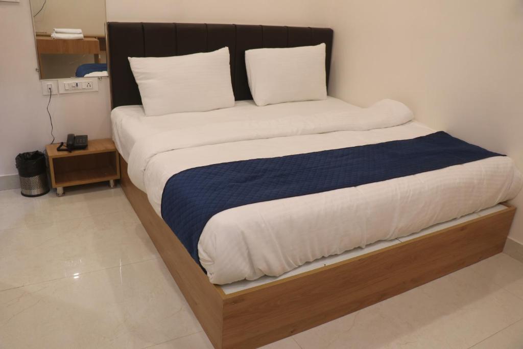 a large bed with a wooden frame in a room at Hotel Lakhdatar in Kota