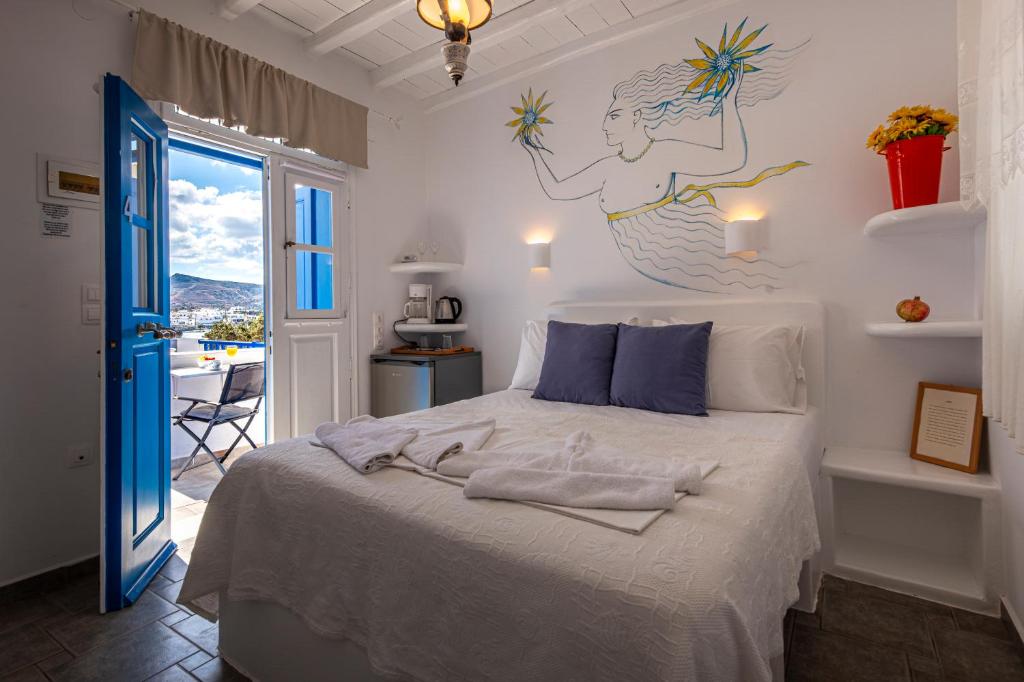 a bedroom with a bed with a mermaid on the wall at Heliotropio Studios & Apartments in Pollonia