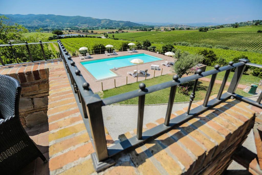 - une vue sur la piscine depuis le balcon d'une maison dans l'établissement Agriturismo Il Divin Casale, à Torgiano