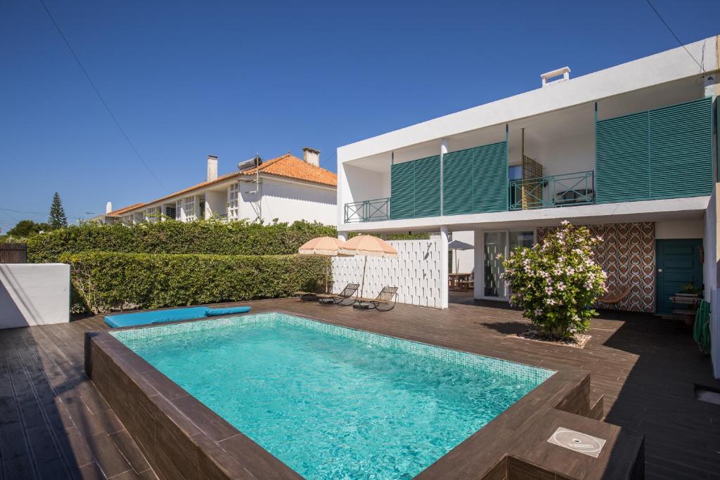 a villa with a swimming pool and a house at Beautiful Boutique House Near the Beach in Costa da Caparica