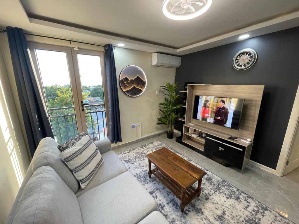 a living room with a couch and a tv at Modern Kingston Apartment Suite With Pool & Ocean View in Kingston