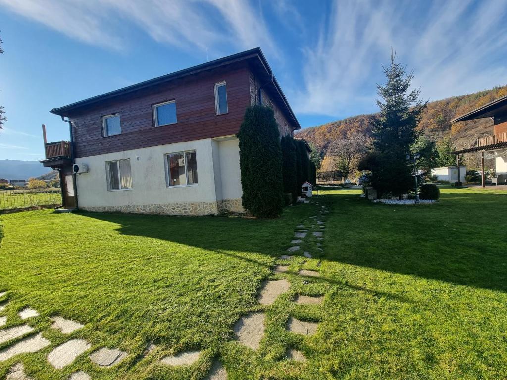 a house on a grassy yard with a pathway at Villa Nikol Apartment #4 in Raduil