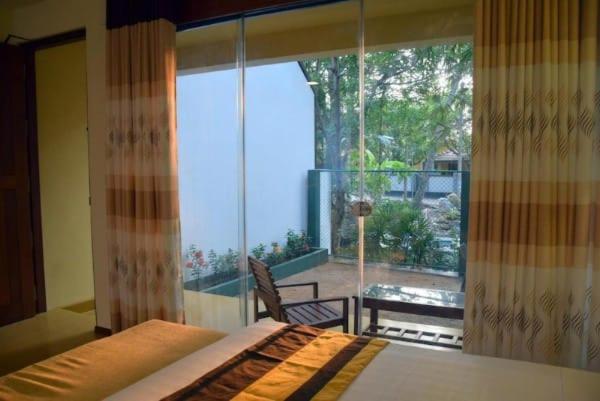 a bedroom with a bed and a large window at Villa Rustic in Negombo