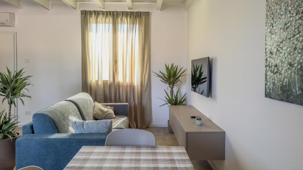 a living room with a blue couch and a table at Cascina Pizzo in San Martino Olearo