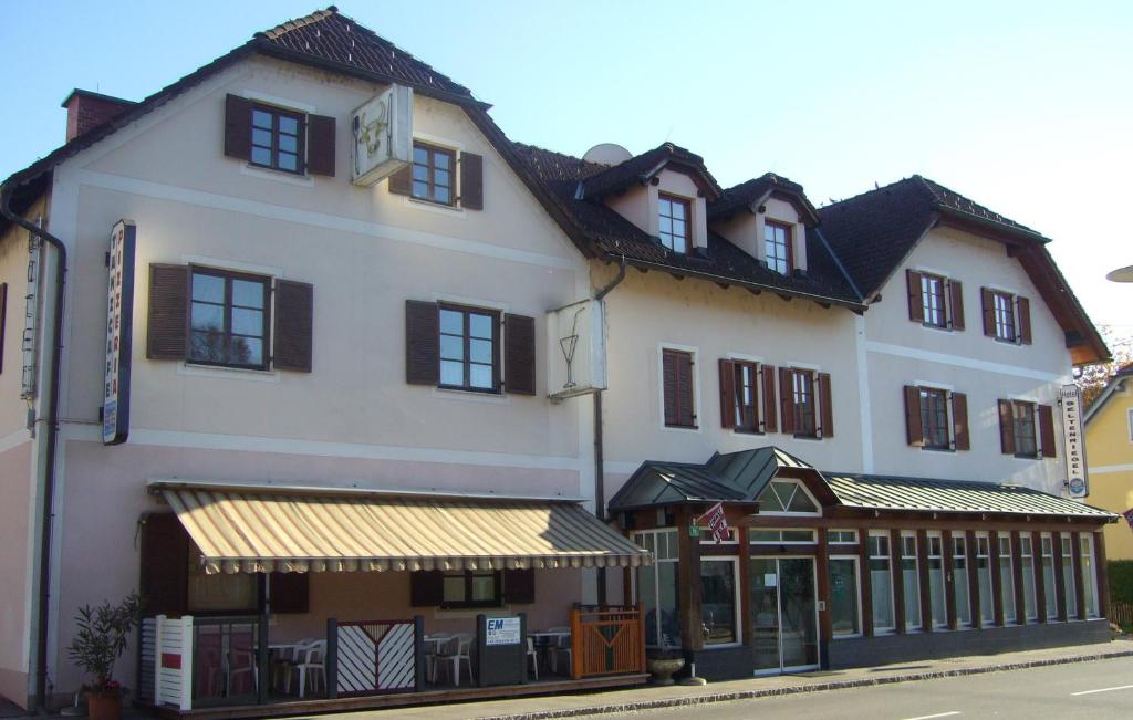 a large white building with a store on a street at Hotel Seltenriegel in Wies