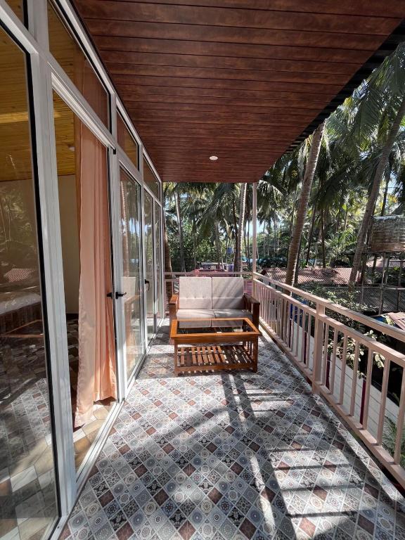 a porch of a house with a couch on it at The Racha Agonda in Agonda