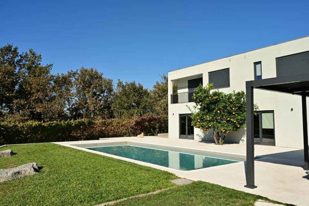a house with a swimming pool in a yard at Sapateiro Guest House in Tabuado