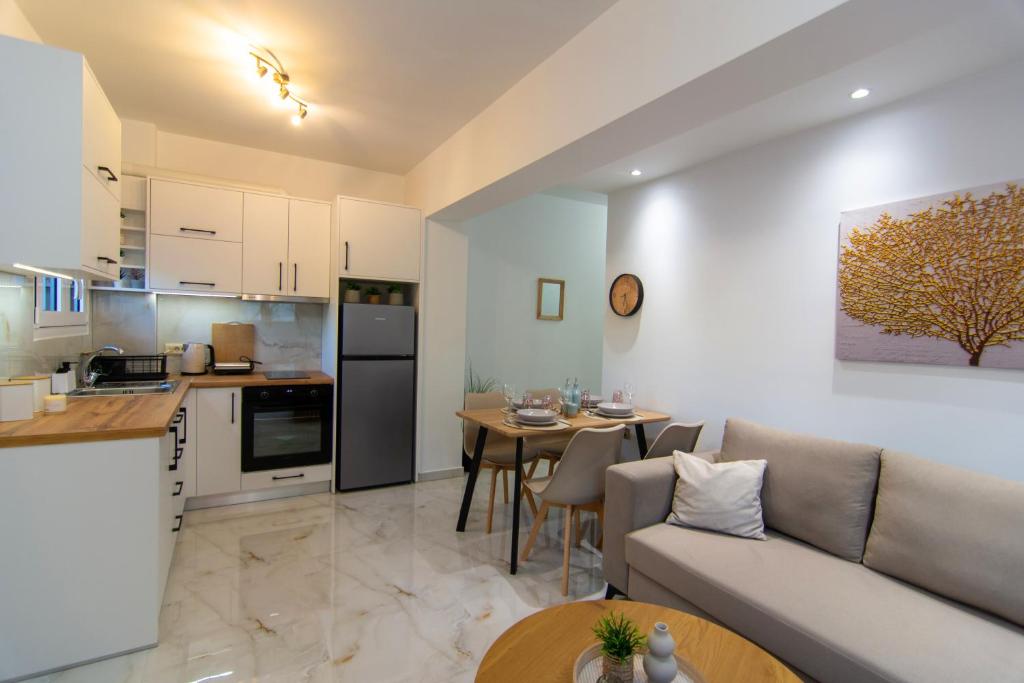 a kitchen and living room with a couch and a table at Amelia Summer Homes in Pérdika