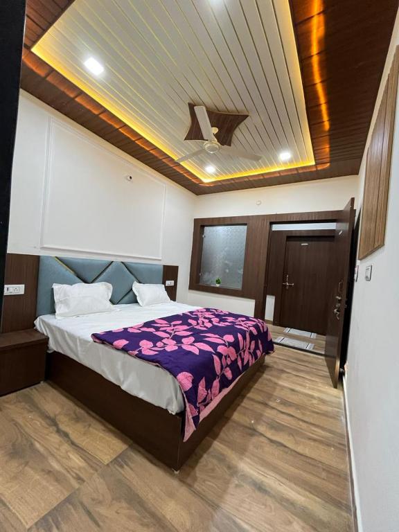 a bedroom with a bed with a purple comforter at Hotel Raghav in Orchha