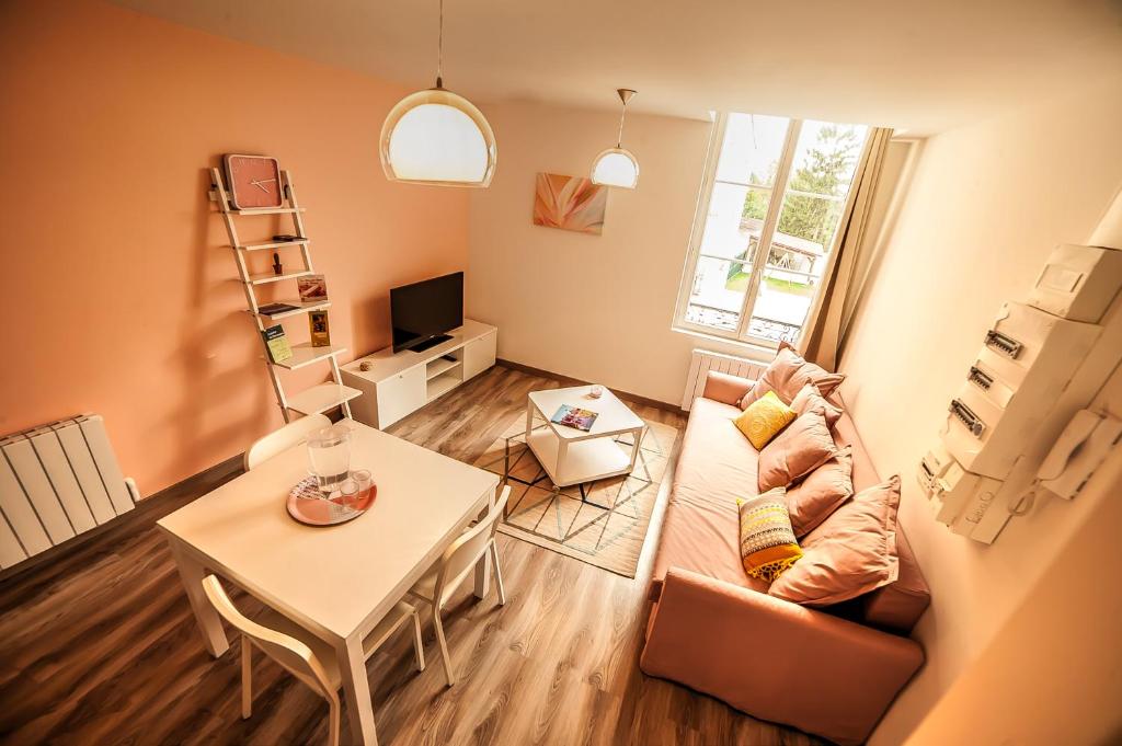 - un salon avec un canapé et une table dans l'établissement Le Millésime, à Châlons-en-Champagne