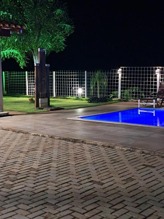 an empty swimming pool at night with a fence at Rancho em Capitólio-MG in Capitólio