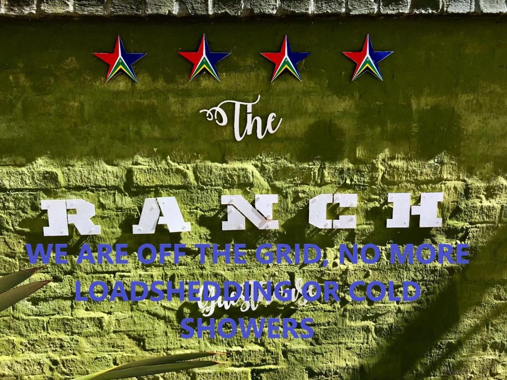 a sign on a brick wall with stars at The Ranch Guesthouse in Potchefstroom