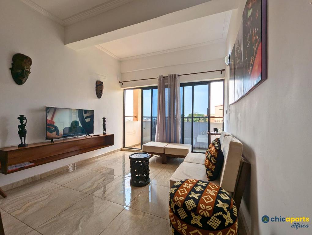 un soggiorno con un divano e una grande finestra di Chic studio with amazing view a Yaoundé