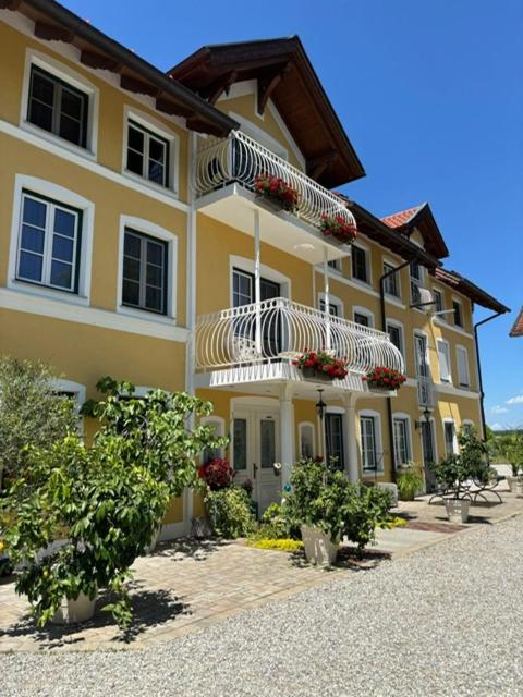 a large yellow building with umbrellas in front of it at Landgut zur Mühle in Dorfen