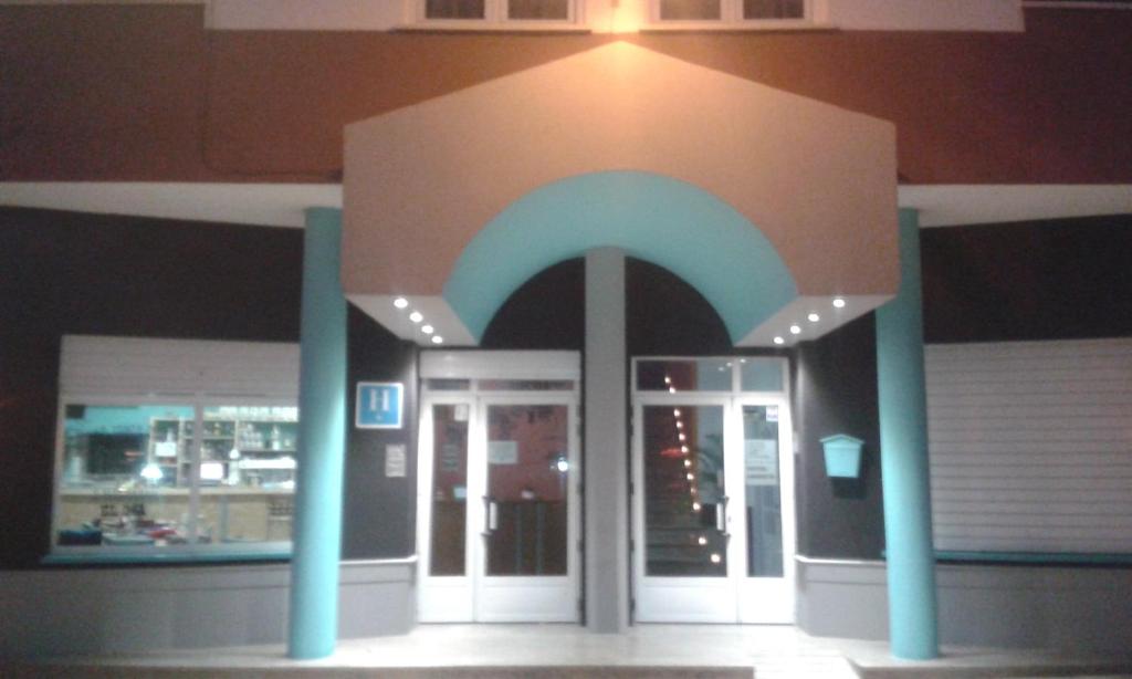 uma entrada para um edifício com colunas azuis e uma porta em Hotel Cervantes em Mahora