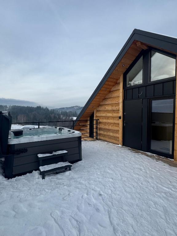 a hot tub on the roof of a house in the snow at Apartament Świerkowa Osada in Istebna