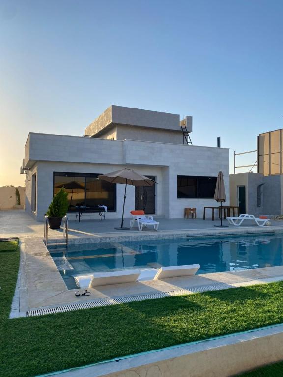 a swimming pool in front of a house at شاليه الدرة Durra Chalet in Amman