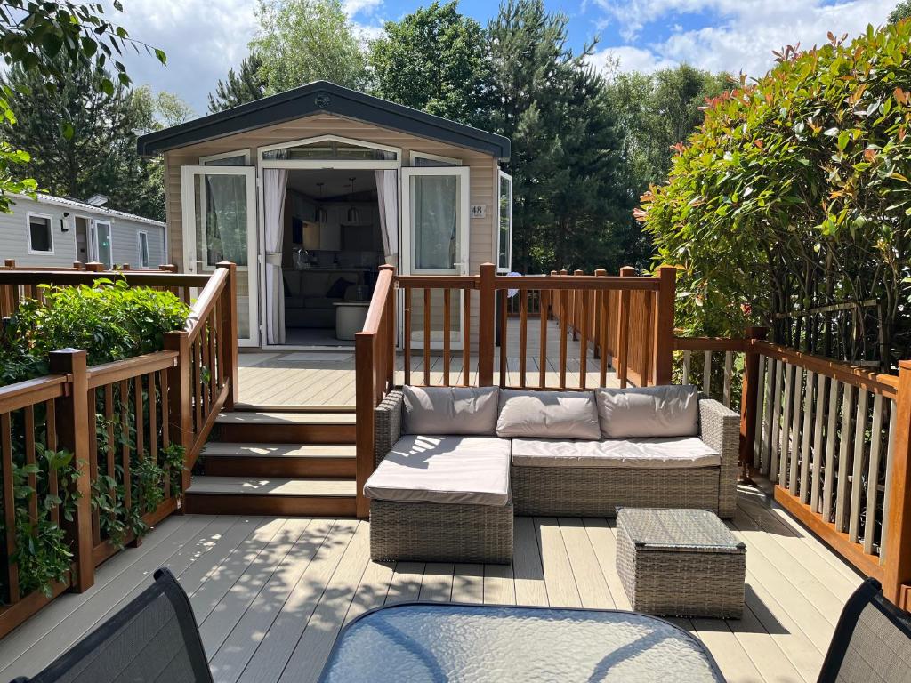 a deck with a couch and a gazebo at 23 The Brambles - Haven Cleethorpes Beach in Humberston