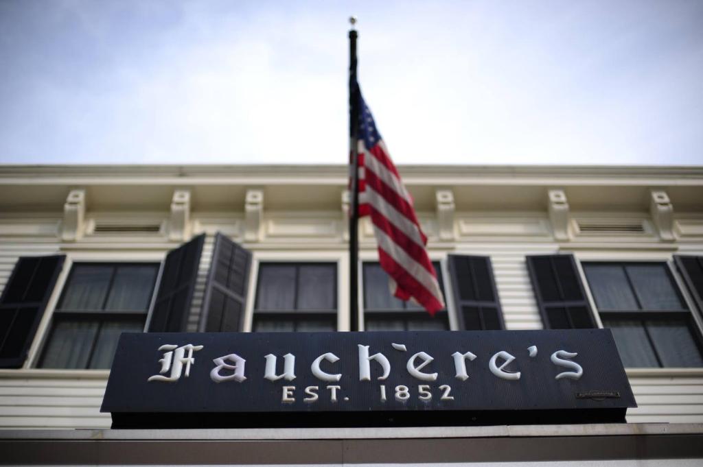 una bandera ondeando frente a un edificio con una señal en Hotel Fauchere, en Milford