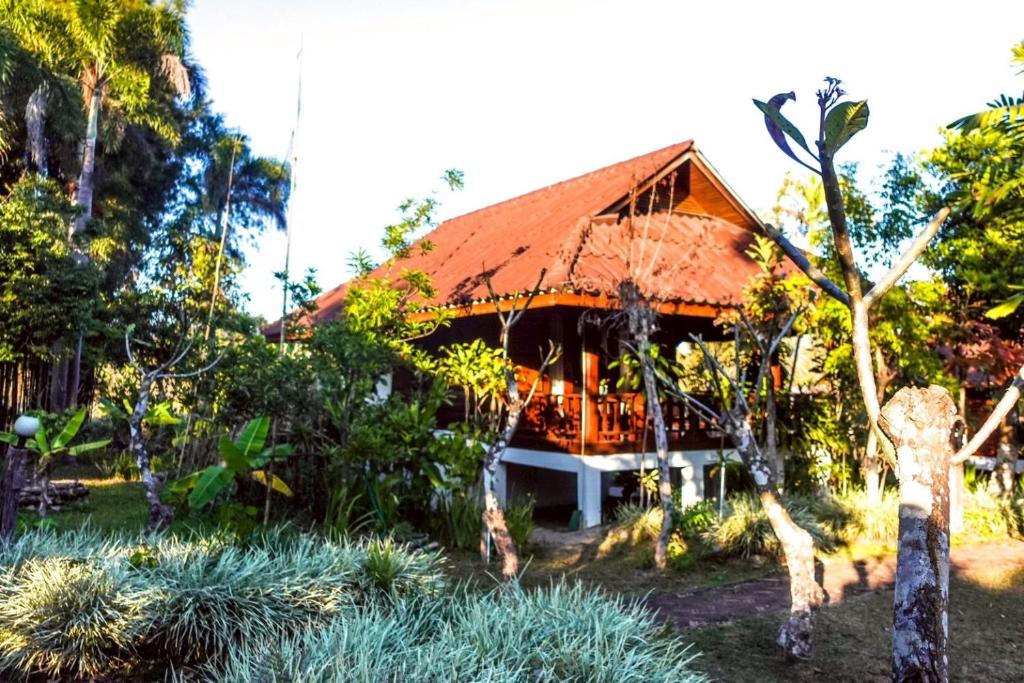 a house with an orange roof in a garden at Le mont pai resort in Pai