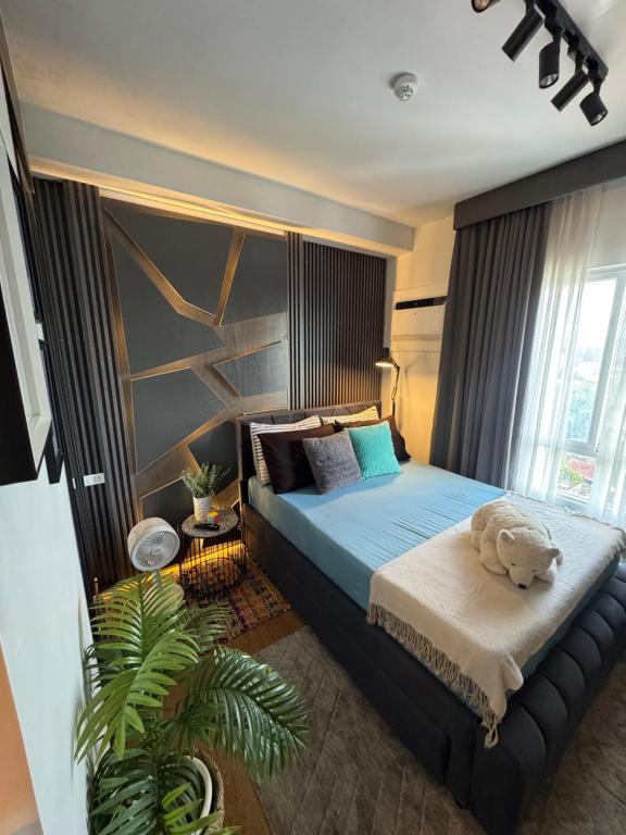 a bedroom with a teddy bear sitting on a bed at Studio McBi in Davao City