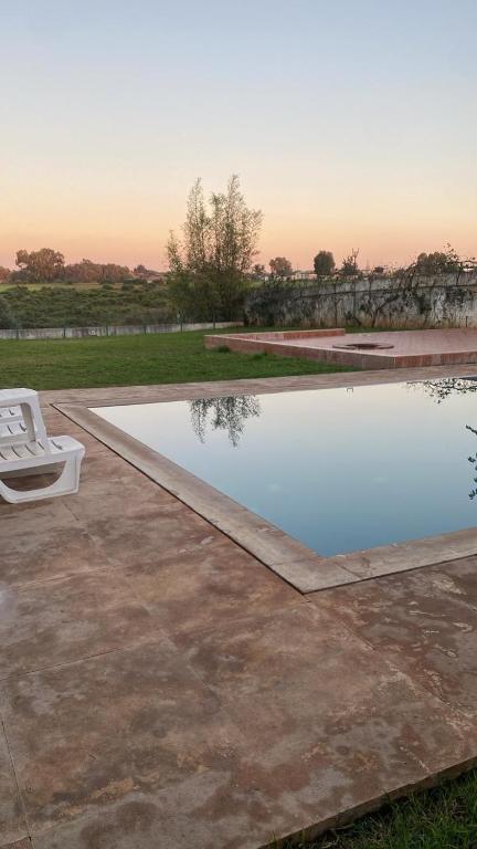 a white chair sitting next to a swimming pool at Big Villa In Rabat in Rabat