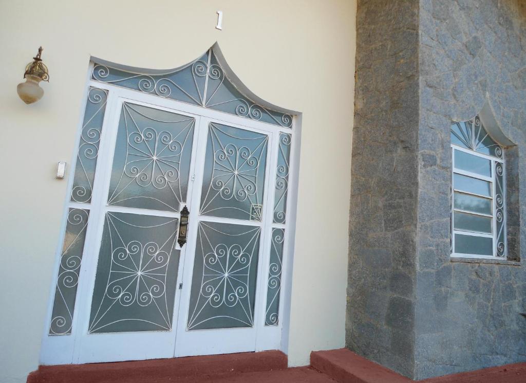 Una puerta en una habitación con ventana en Hostel e Pousada Solar, en Poços de Caldas