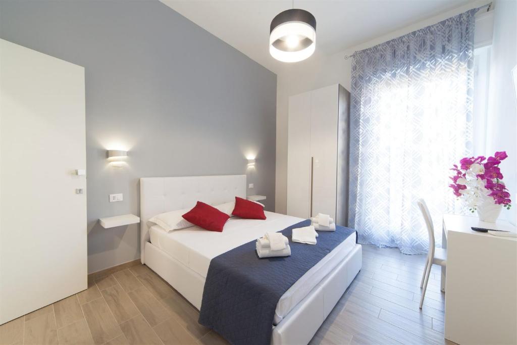 a bedroom with a white bed with red pillows at Bed & Breakfast Tramonti in Trapani