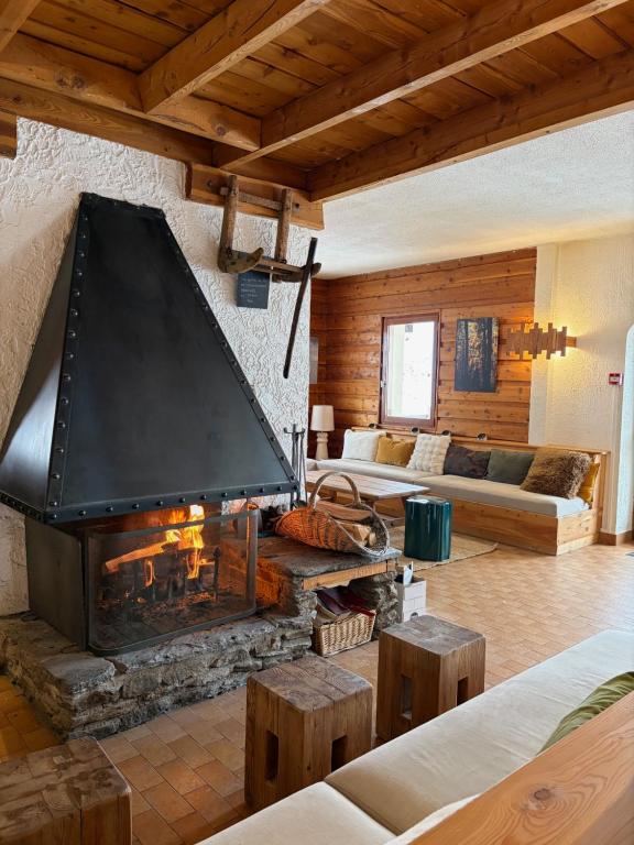 a living room with a large fireplace and a couch at Le Grand Tetras in Saint-Véran
