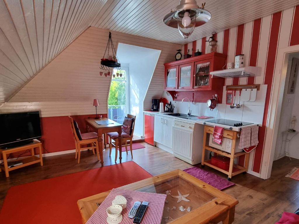 a kitchen with red and white striped walls and a table at Ferienwohnung Leuchtfeuer in Burhave