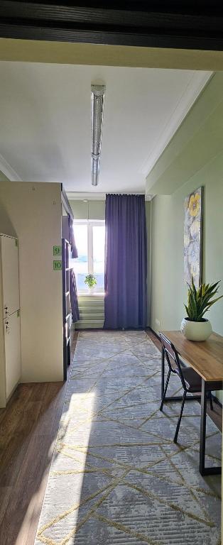 a living room with a table and a purple curtain at Koktem hostel in Aktobe