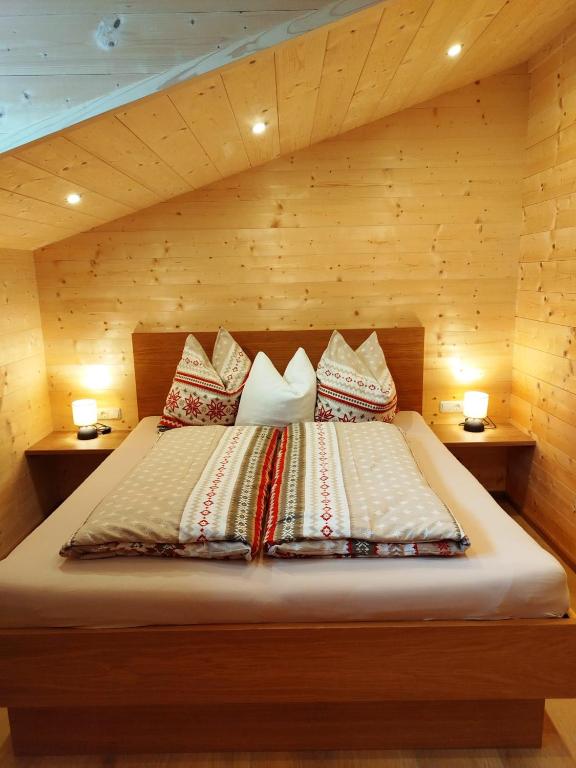 a bedroom with a bed with pillows on it at Ferienwohnungen Tauernalm in Heiligenblut