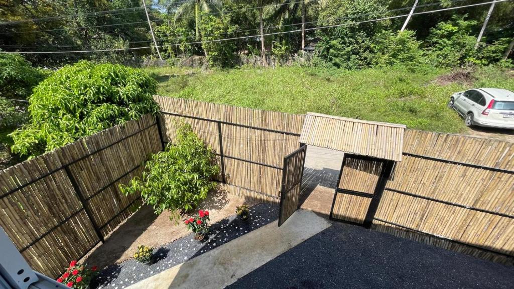 an aerial view of a wooden fence with flowers at Secret Garden House - 2BR Cozy Home with Garden & Workspace in Ban Tai