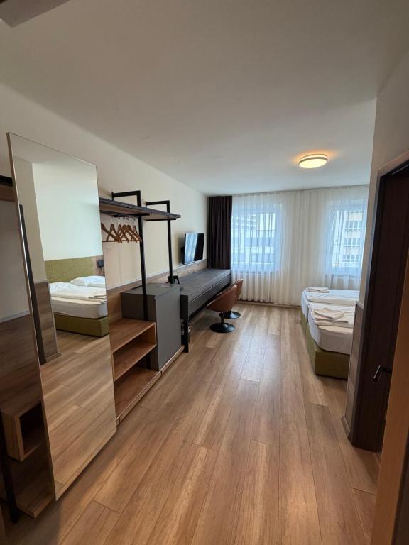 a large room with a bed and a desk in it at Turm Inn 24H Self Check In By H&H Hotels in Linz
