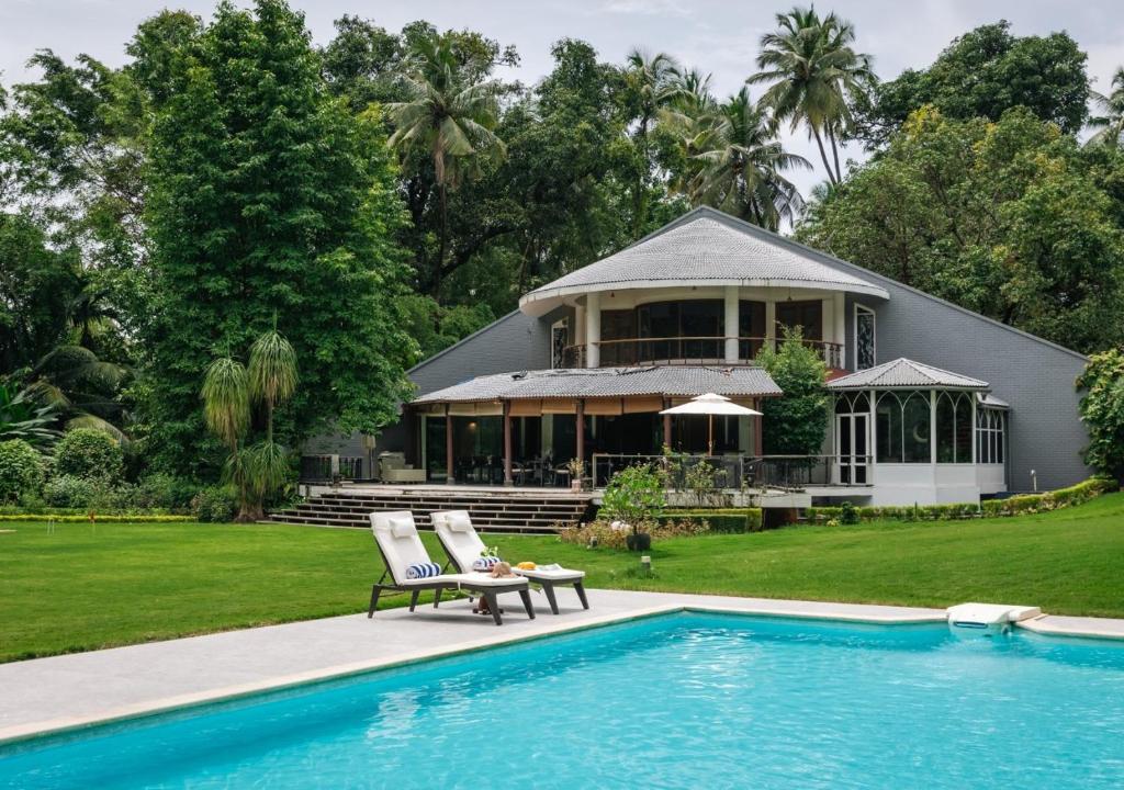 a house with a swimming pool in front of a house at LohonoStays Villa Lani in Alībāg