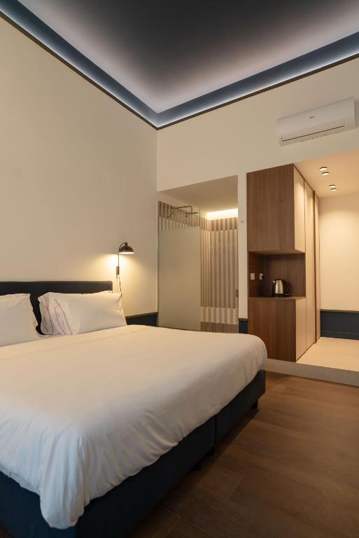 a bedroom with a large white bed and a closet at Maison Petronilla in Naples
