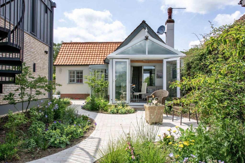 a house with a conservatory in a garden at Quayside Cottage in Waldringfield