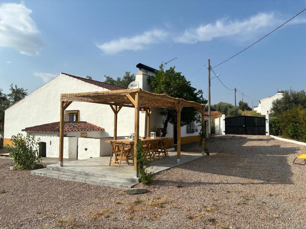 a wooden pavilion with a table in front of a building at Monte do Vale in Casa Branca