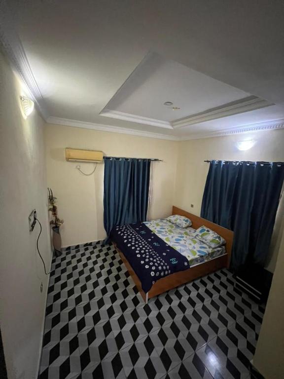 a small bedroom with a bed and blue curtains at Funkytee Apartments in Isasi